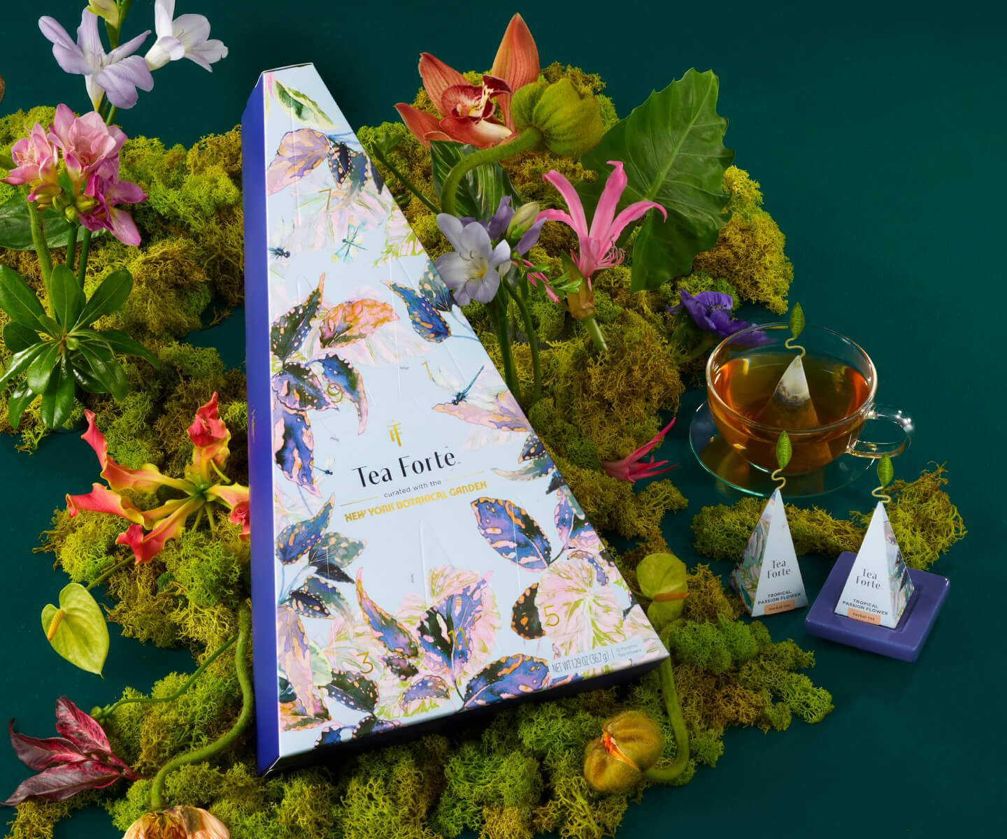 The Demoiselle 12 Days of Blissful Teas Advent Calendar nestled into a bed of moss and flowers.