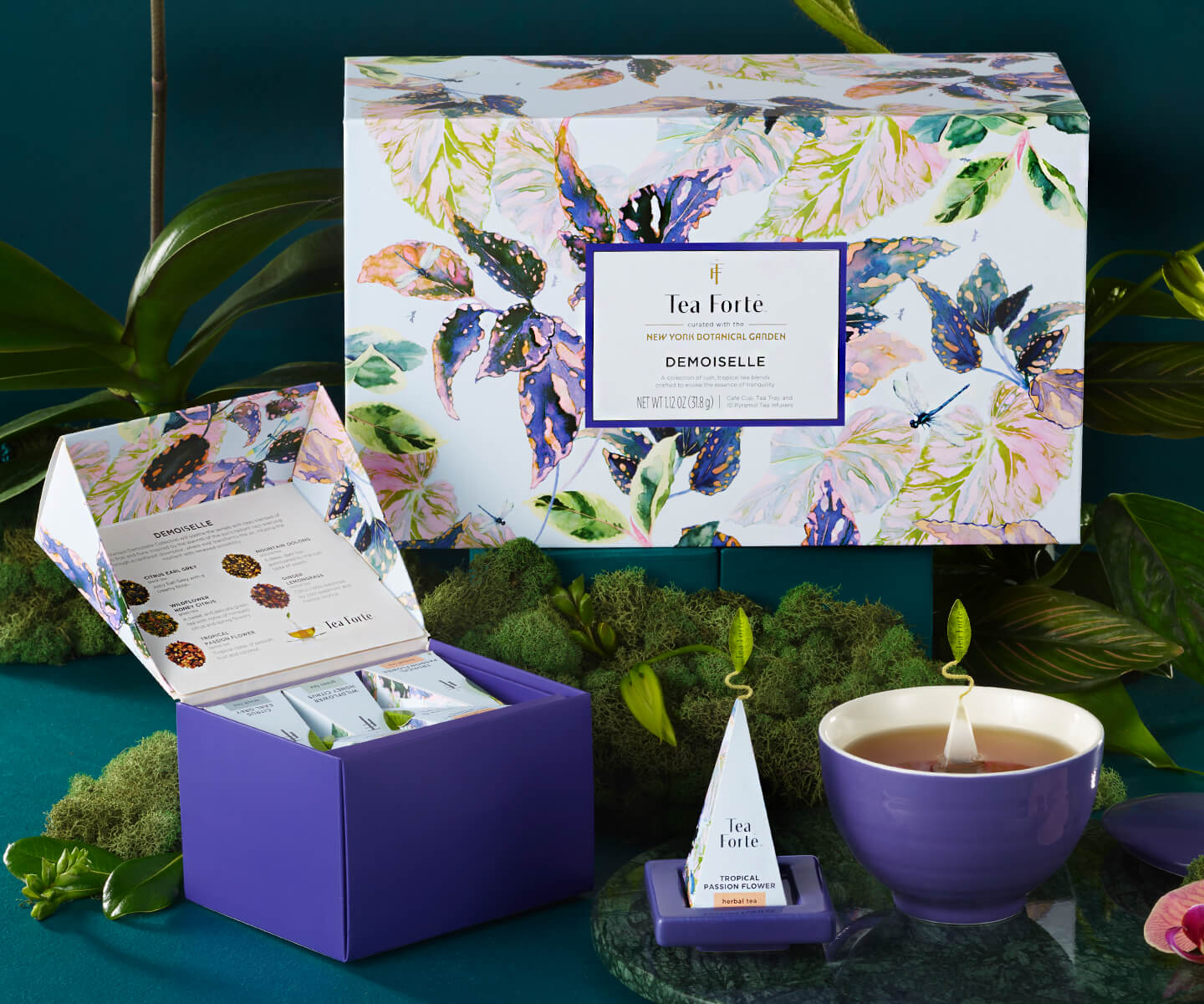 Demoiselle Gift Set on a table with the box lid open, on a table with flowers.